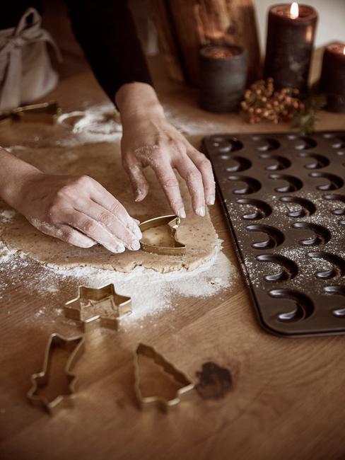 Kersthapjes header Kersthapjes uit de oven van ovenschaal met vormen op houten tafel