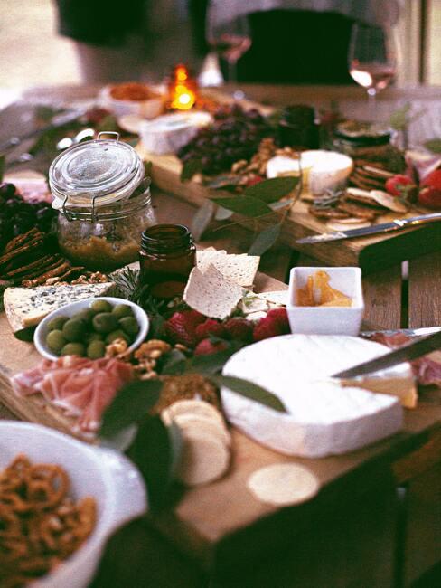 Een bord met kaas, vleeswaren en fruit op een houten tafel