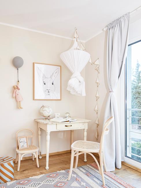 Kinderkamer inspiratie: een kamer in beige en wit met ook een wit bureau en stoel, met ingelistje print en decoratieve objecten op de muur