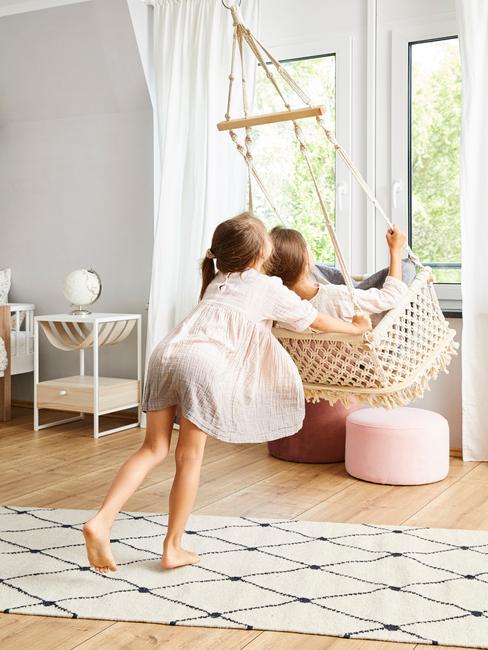 Kinderen spelen in de kamer met een schommel