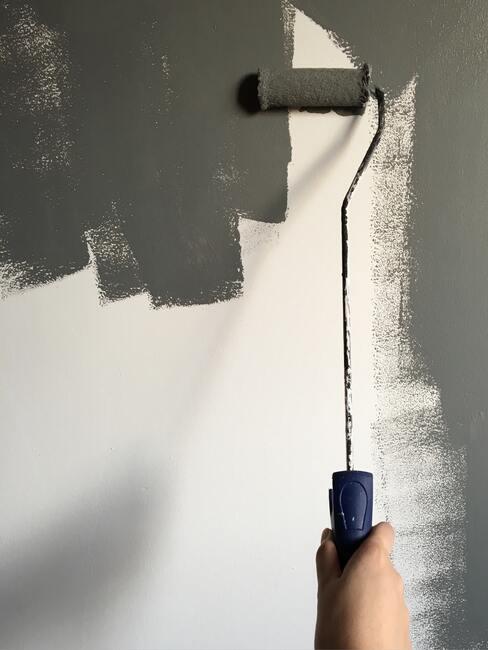 Verf de muur grijs met een roller