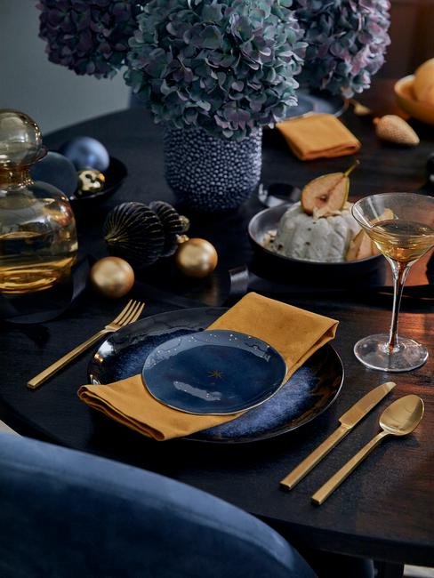 Adventskalender: gedekte tafel in blauw en goud kleur met kaarsen en gele servetten