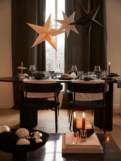 Adventskalender: Kerstdecoratie in een beige woonkamer met zwarte stoelen en een zwarte tafel