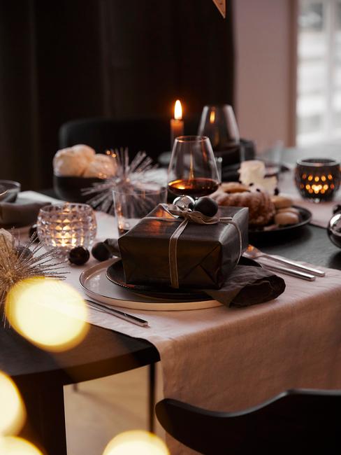 Gedekte tafel met serviesset, witte tafelloper en cadeau