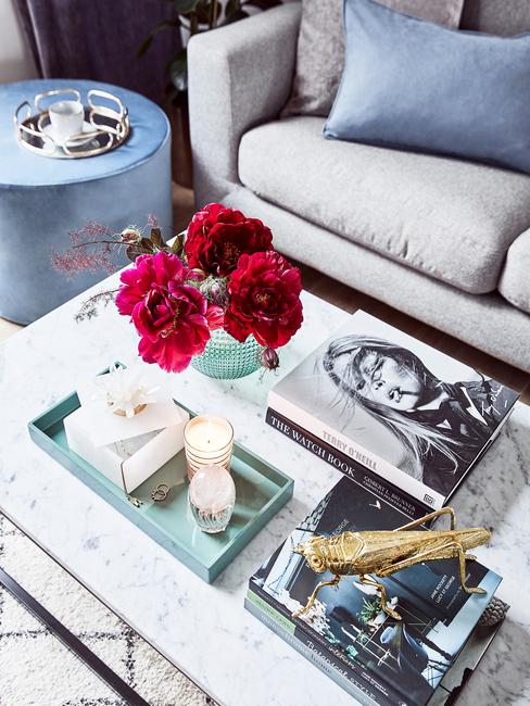 Koffietafelboek op marmeren salontafel in wit en grijs met glazen vaas met bloemen