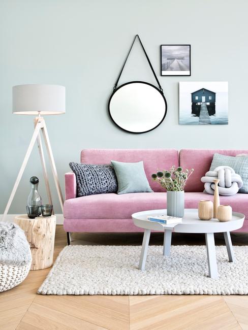 Houten decoratieve elementen in een woonkamer op een salontafel naast een roze zitbank