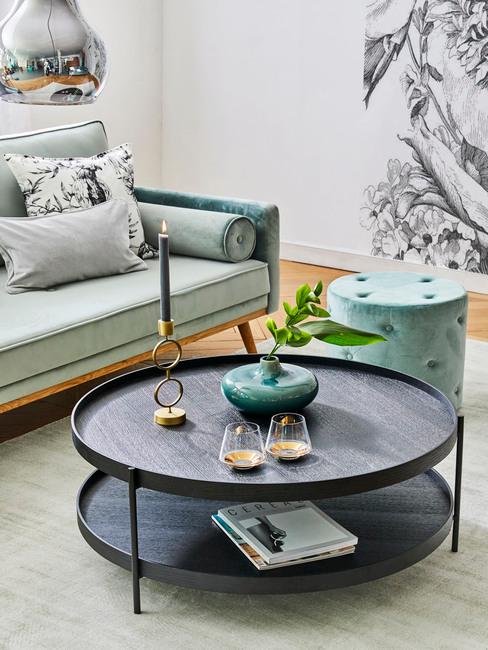 Grote salontafel in houten look met kaars en vaas naast een zitbank in turquoise kleur