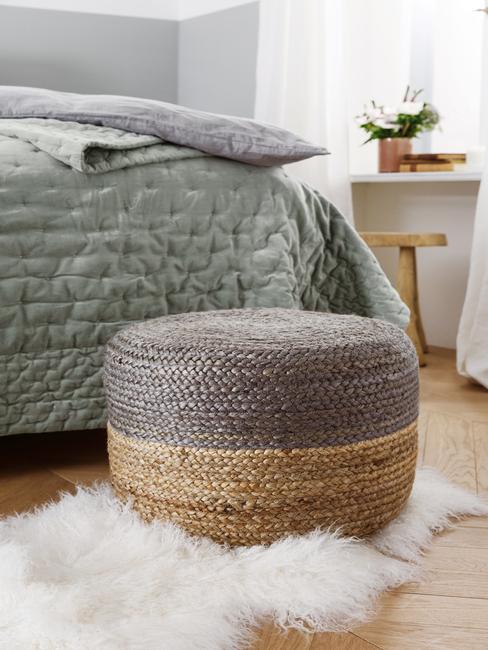 Neutrale tinten: rotan poef naast een comfortabele zitbank in groen