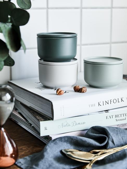 scandinavische keuken met groene opbergbakjes en stapel kookboeken