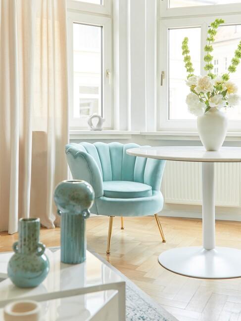 blauwe fauteuil aan ronde witte eettafel