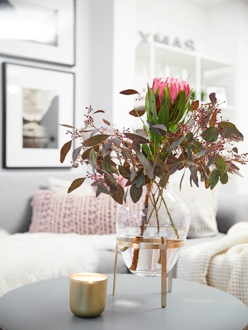 Glazen vaas met bloemen in woonkamer in wit