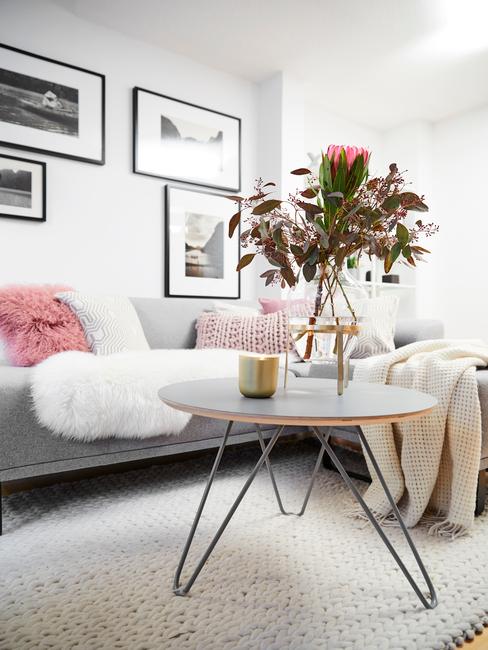 Woonkamer meubels: salontafel met glazen vaas met bloemen op zacht vloerkleed