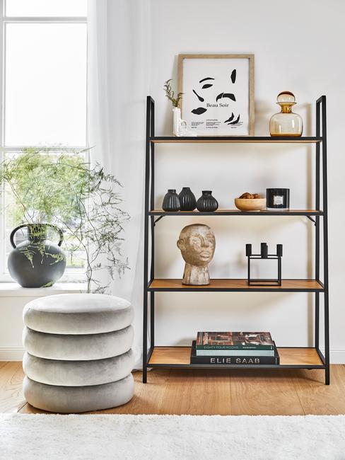 wandkast met decoratieve acessoires en ronde grijze poef