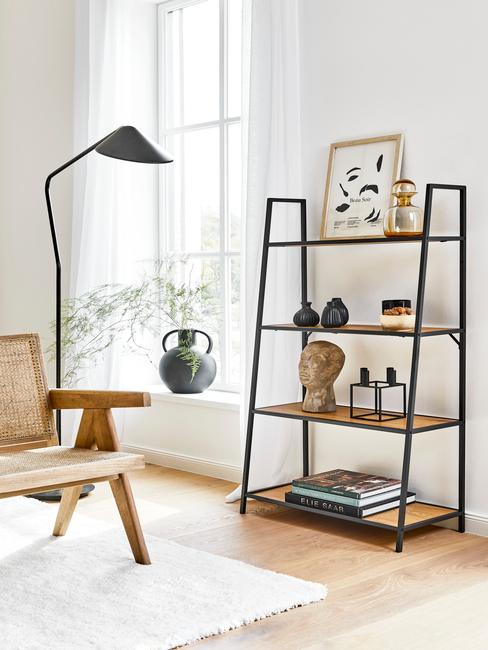 hoge zwarte lamp en rotan stoel met open wandkast