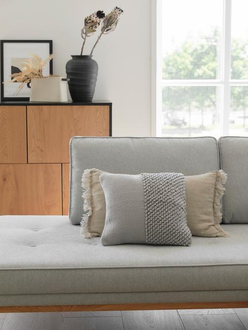 Grijze bank in woonkamer met decoratieve kussens