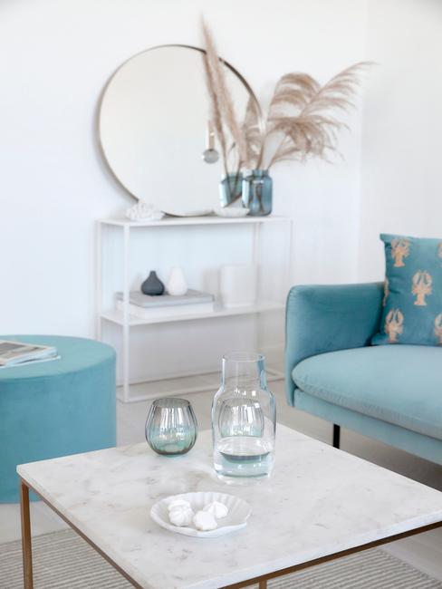 woonkamer met marmeren salontafel en blauwe bank
