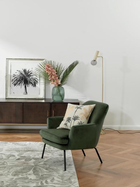 woonkamer met groene armleunstoel en jungle vloerkleed
