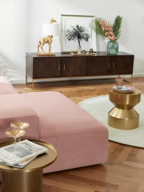Grote woonkamer met roze marsmallow bank en gouden bijzettafel