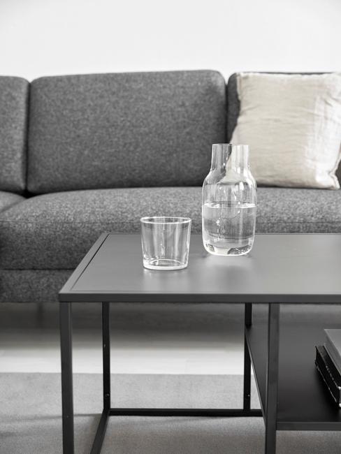 grijze bank in woonkamer met zwarte bijzettafel