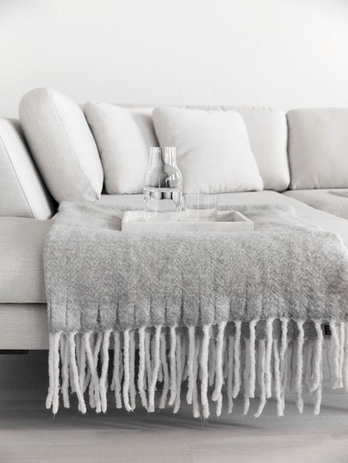 witte bank in woonkamer met grijze plaid
