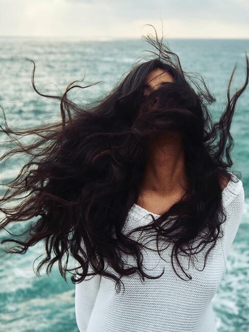 beach look hair1 Vrouw met grote bos zwarte haren aan het uitwaaien op het strand