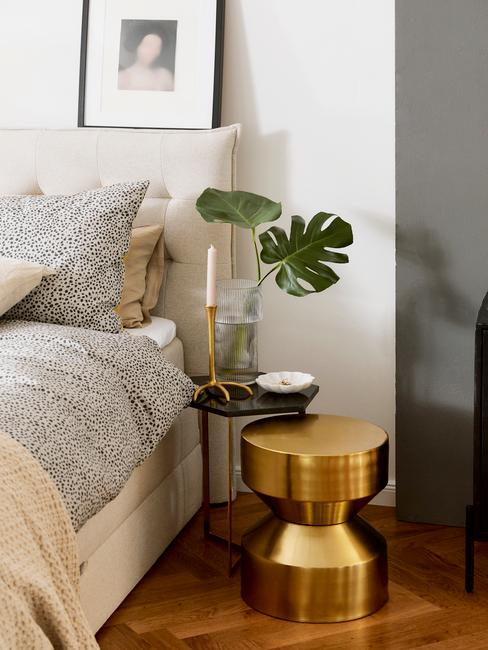 toupe bed met grijze deken en gouden tafel
