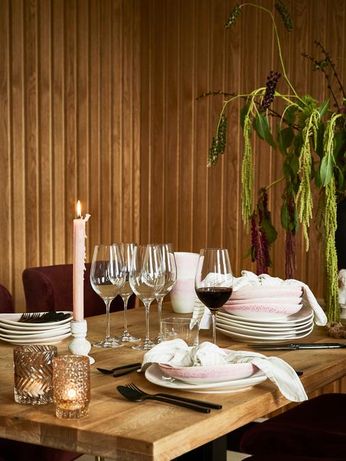 eten met vrienden : witte serviesgoed op houten tafel en wijnglazen naast kaarsen
