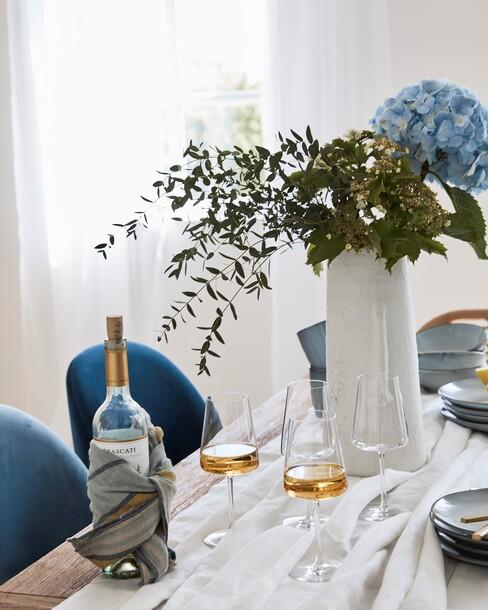 wijn met boeket bloemen op gedekte tafel