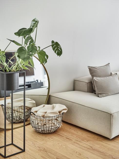 Comfortabele beige bank met sierkussens naast een houten salontafel met kaarsen