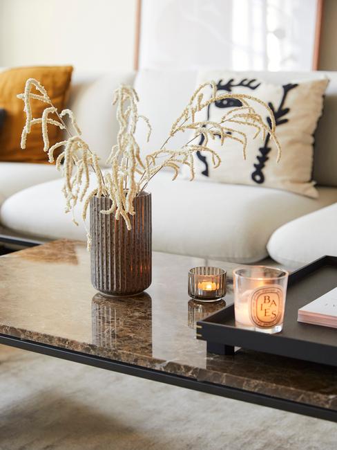 Woonkamer met glazen salontafel en bloemen
