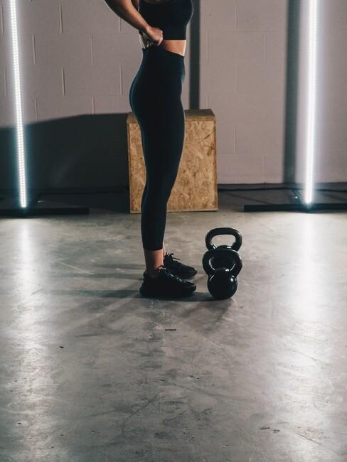 Vrouw met twee kettlebels
