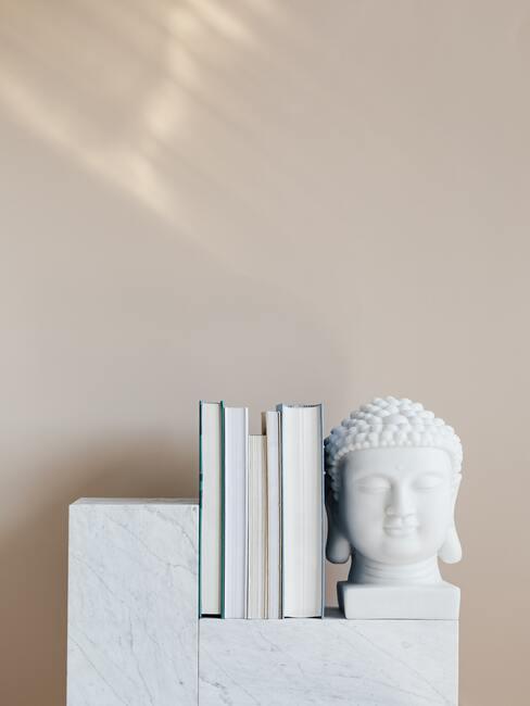 Decoratief object Buddha op wit dressoir naast boeken