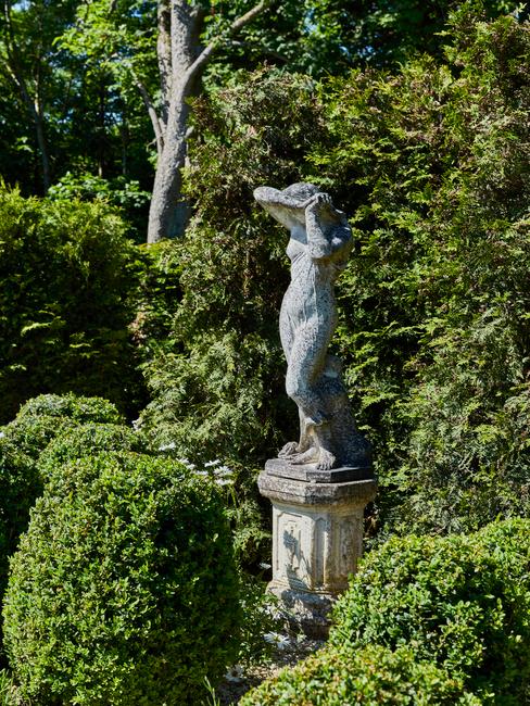 sculptuur in een tuin vol bomen en bloemen