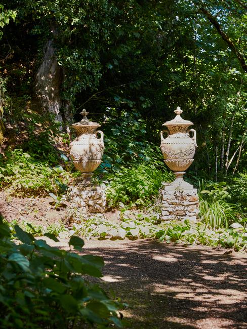 sculptuur in een tuin vol bomen en bloemen