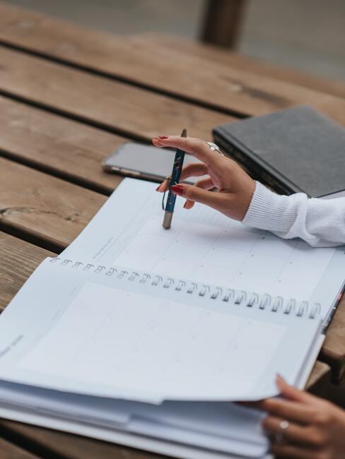 pexels-anete-lusina-5239790 notitieblok met een potlood en een hand