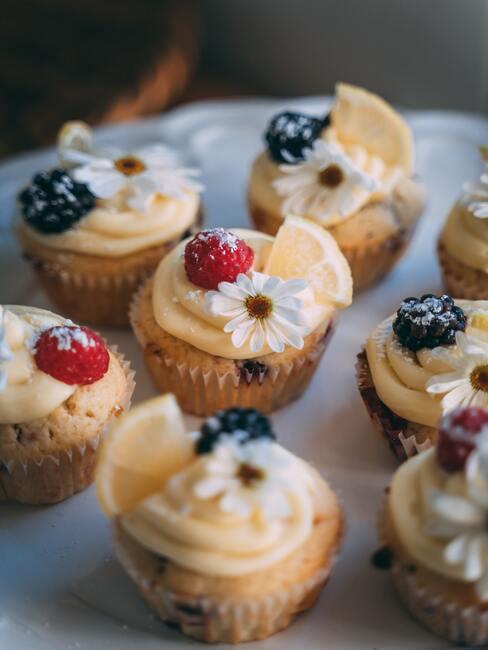 zoete cupcakes met room en fruit op een houten