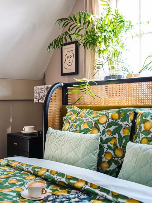 Rotan bed met groene kussens en gekleurd dekbedovertrek