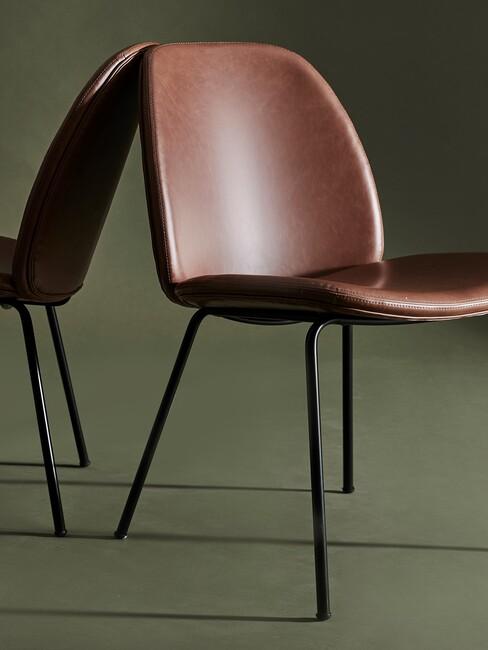 Bruine leren stoelen voor een groene muur