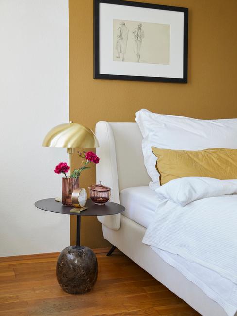 gele muur met grijs bed met geel kussen en witte deken