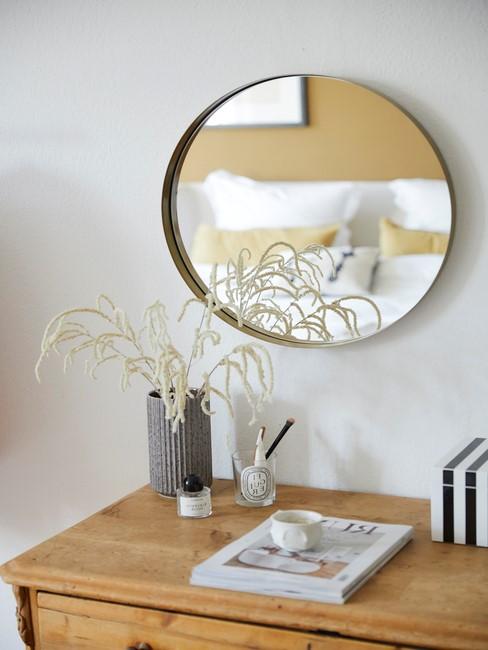 Ronde spiegel boven houten kast