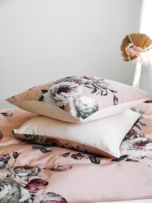 roze bloemenkussens op een bed