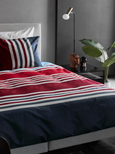 grijze boxspring met kleurijk dekbed