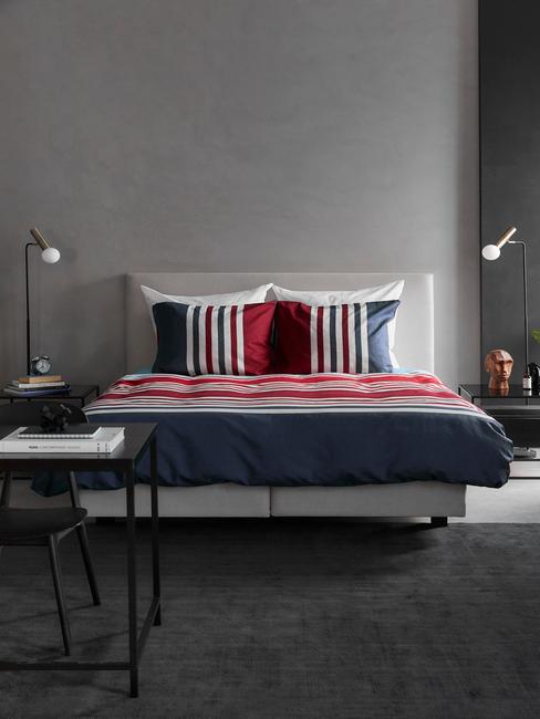 grijs bed met rood, wit, blauw dekbed