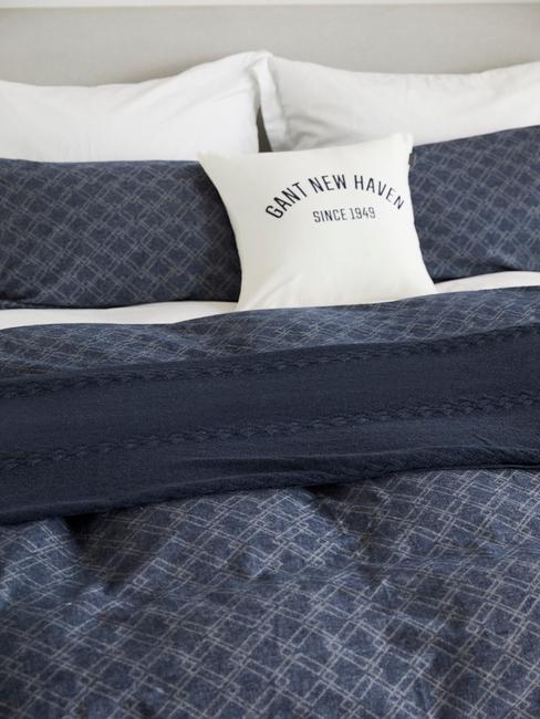 blauw bed met witten kussens