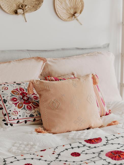 grijs bed met vrolijke kussens met oranje patroon