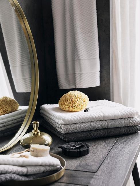 ronde gouden spiegel op donker houten tafel