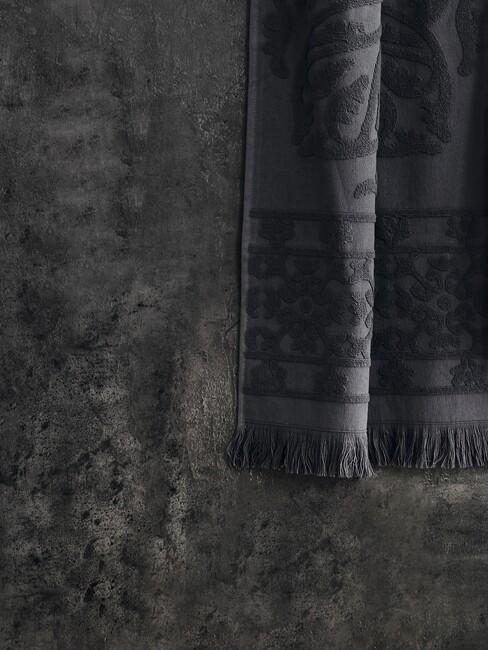 donkere muur met donker geijze handdoek