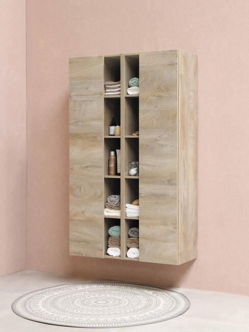 houten kast met kleed en roze muur