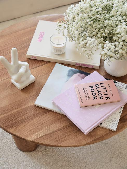 Houten salontafel met boeken, vaas met bloemen en beeldje