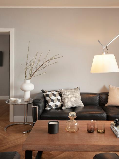 Zwarte leren bank in huiskamer met artemide lamp